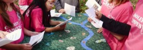 Children cooperating to earn points on The Green Board